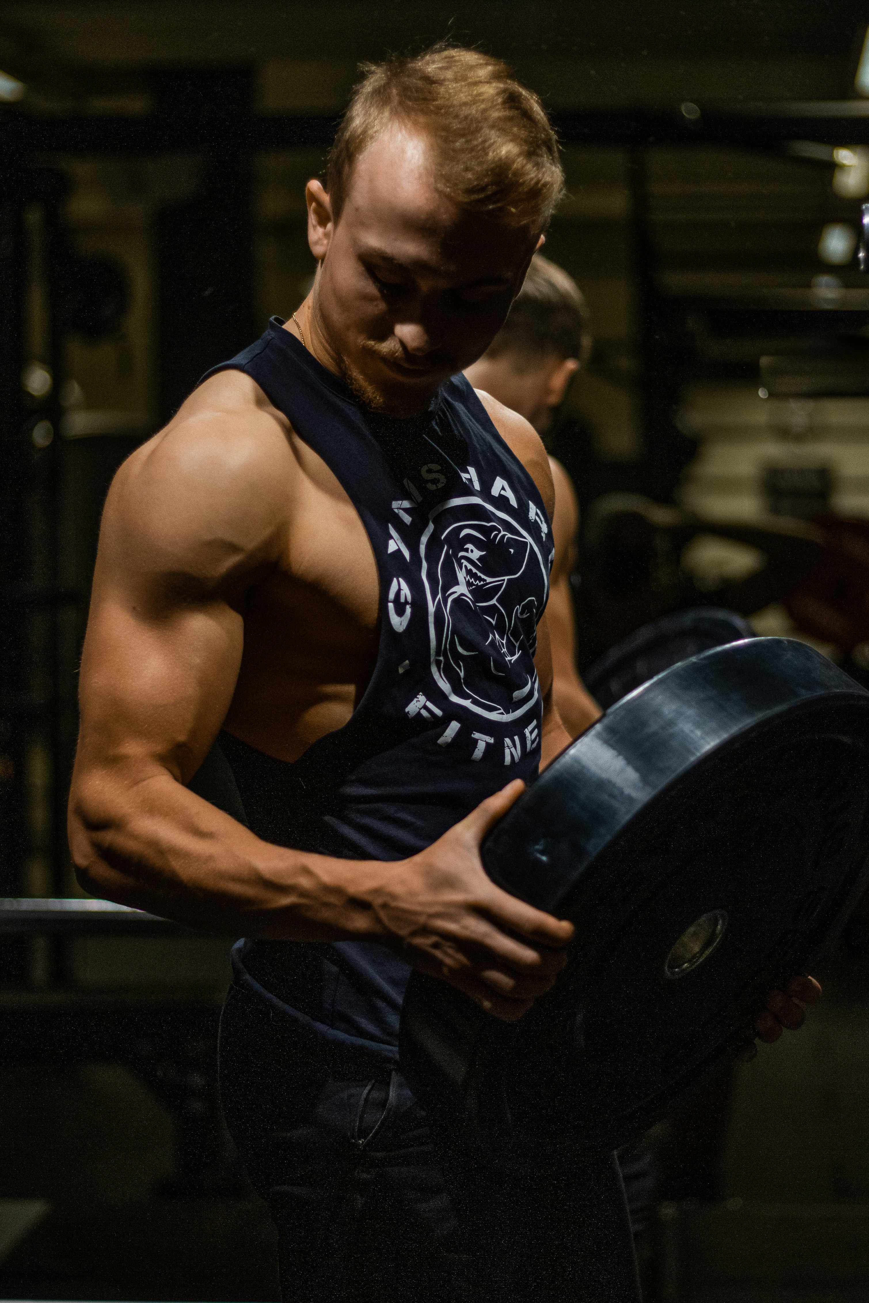 man in black tank top and black pants holding black round plate